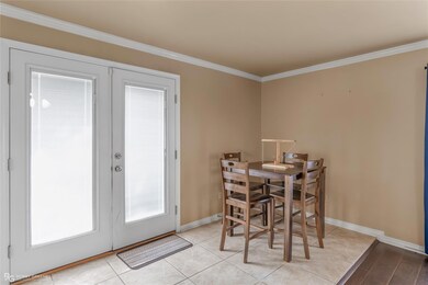 Dining space featuring crown molding, light tile p