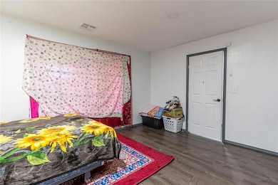 Bedroom with dark hardwood / wood-style floors