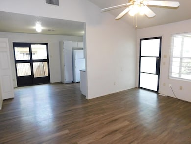 Empty room with a ceiling fan, dark wood-style fl