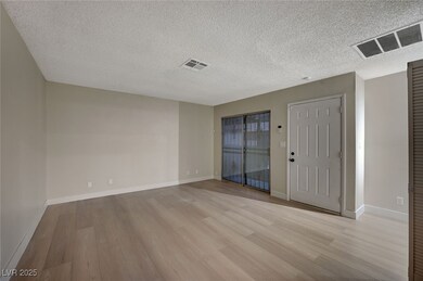 Spare room with a textured ceiling, light wood-typ