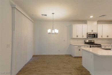 Kitchen with white cabinets, appliances with stain