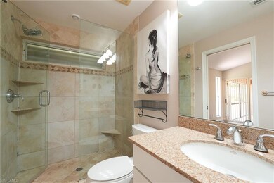 Bathroom featuring toilet, a stall shower, and vanity