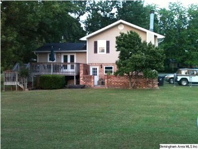 Back of home with large flat yard