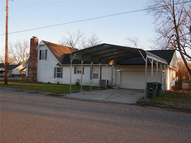 View of front facade with a garage and a carport