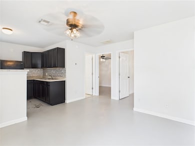 Kitchen featuring a ceiling fan, concrete floors,