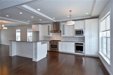 Fabulous chef's kitchen with center island, tons of cabinetry, KitchenAid professional grade appliances all in stainless steel and breakfast area which has door leading to Trex deck.