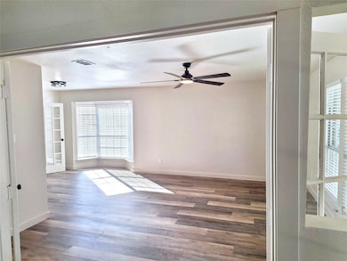 Room with dark wood-style floors, great natural light, and a ceiling fan