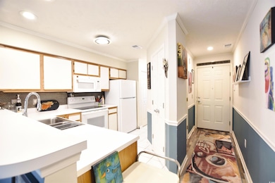 Kitchen with sink, white appliances, tasteful back