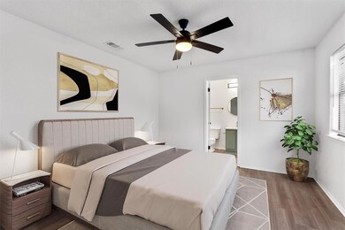 Bedroom with dark wood-style floors, ensuite bath