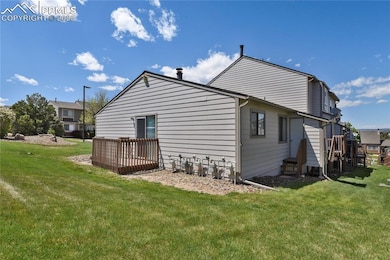 Rear and side view of house with deck, lawn and storage closet with entry steps
