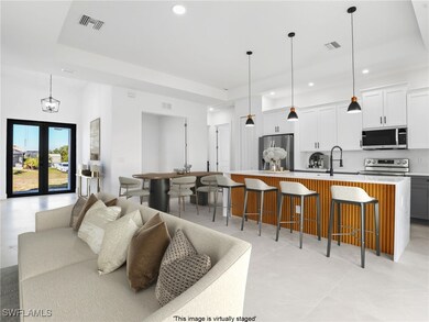 Living area featuring a tray ceiling, visible vent