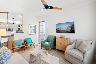 Living room with ceiling fan, ornamental molding,