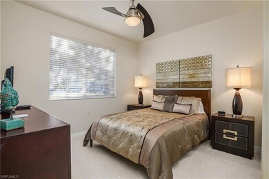 Carpeted bedroom with a ceiling fan and baseboards