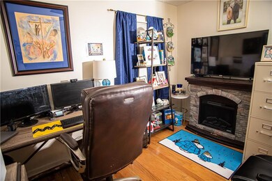 Office area with wood finished floors and a fireplace