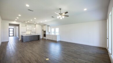 Unfurnished living room featuring ceiling fan, pl