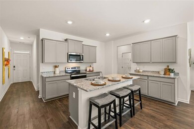 Kitchen with appliances with stainless steel finishes, dark hardwood / wood-style floors, gray cabinetry, and sink