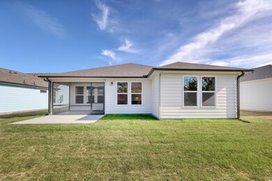 Rear view of house with a lawn and a patio