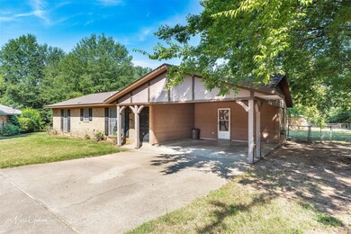 Ranch-style house with a front lawn and a carport