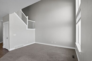 Unfurnished room with dark carpet, a high ceiling, and stairway