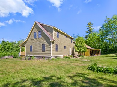 back of house with wood shed