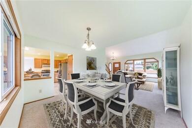View from the dining room looking back into the living room and peeking into the large, eat-in kitchen. This floor plan is perfect for entertaining.