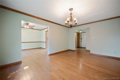 Wood floored empty room featuring crown molding, a
