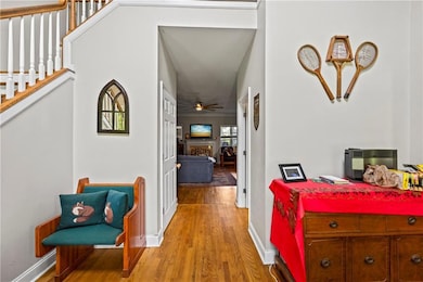 Hall with wood finished floors and stairway