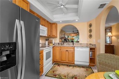 Kitchen with ceiling fan, a raised ceiling, orname