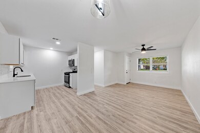 Unfurnished living room featuring ceiling fan, lig
