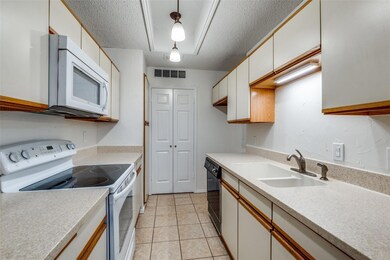 Kitchen with sink, white appliances, hanging light