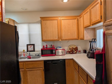 Kitchen featuring black appliances, a sink, light
