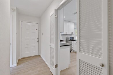 Hallway featuring light wood-type flooring and ba