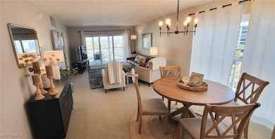 Dining room featuring a notable chandelier, a text