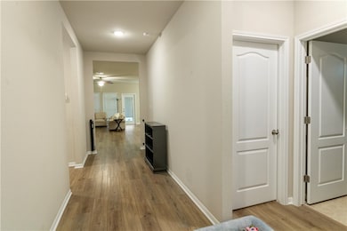 Hallway featuring light wood-type flooring and bas