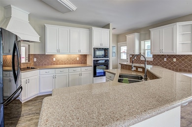 Kitchen with black appliances, open shelves, wood