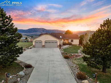 View of front facade featuring a yard, stucco siding, a mountain view, driveway, and an attached garage