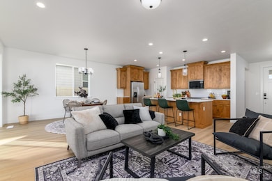 Living area featuring light wood-style floors, recessed lighting, and a chandelier