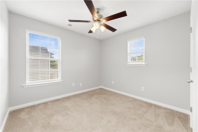 Empty room with light carpet and ceiling fan