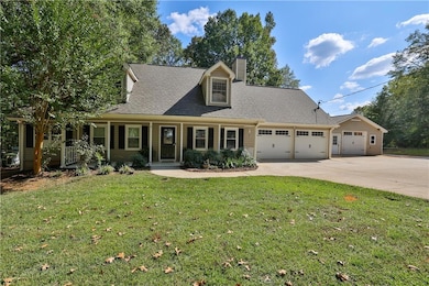 View of front of home with a front yard, a garage, and covered porch