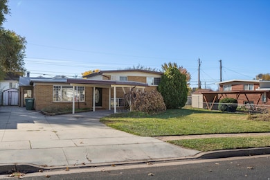 Traditional-style home featuring driveway, a storage shed, brick siding, and a carport