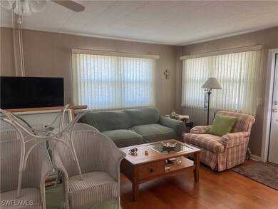 Living area with wood-type flooring and ceiling fa