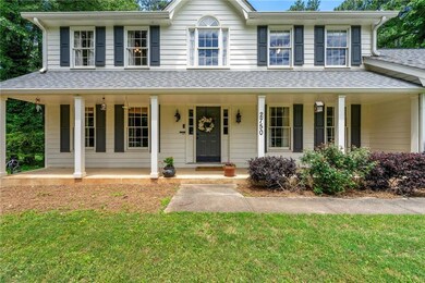 View of front of property featuring covered porch, a shingled roof, and a front lawn
