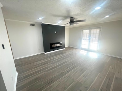 Unfurnished living room with crown molding, wood f