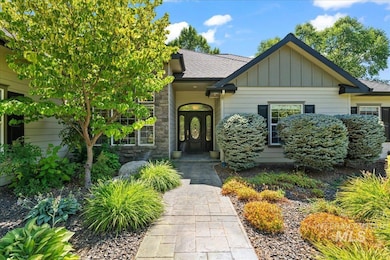 View of front of property with board and batten siding, roof with shingles, and stone siding