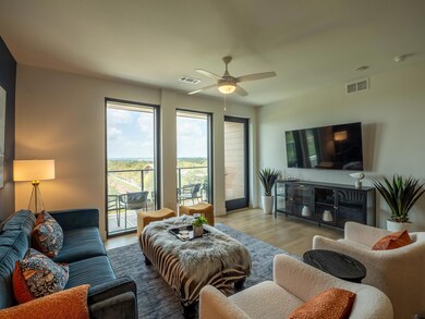 Living room featuring a ceiling fan and wood fini