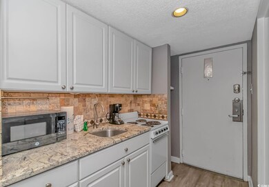 Kitchen featuring white stove, sink, decorative ba