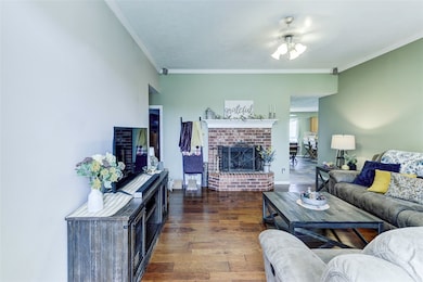 Living room with a ceiling fan, a brick fireplace,
