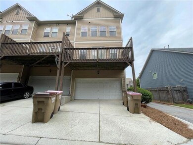 View of property featuring a garage, driveway, boa