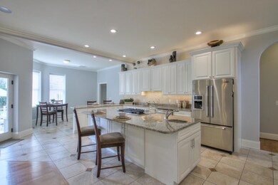 Main level kitchen is a chef's haven offering crisp white custom cabinetry, quarts over-sized island and  Jenn-Air stainless steel appliances with a double oven!  
