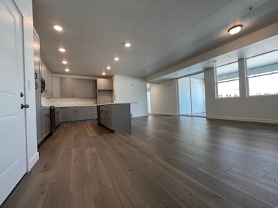 Kitchen featuring gray cabinets, light countertops, dark wood-style floors, open floor plan, and recessed lighting